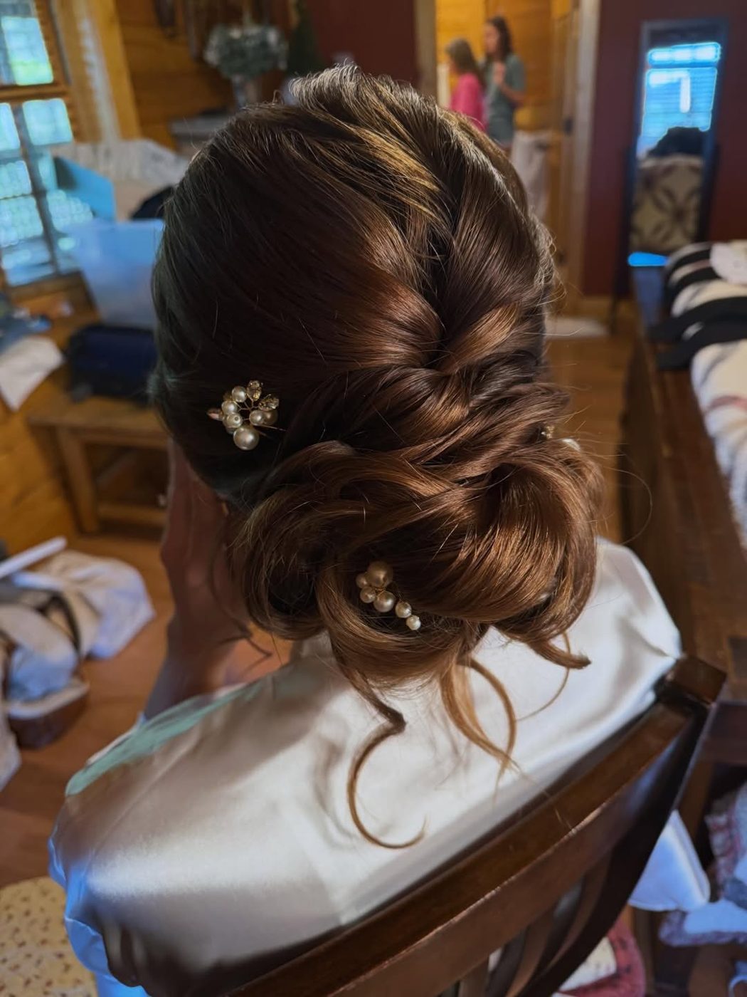 A low bridal chignon finished with pearl pins